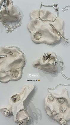 several pieces of jewelry are displayed on a white surface with silver chains and clasps