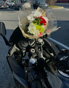 a motorcycle parked on the street with a bunch of flowers