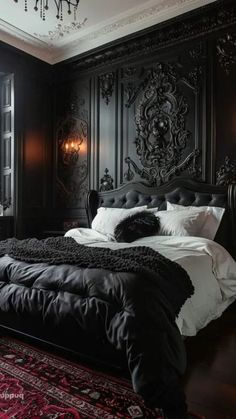 a large black bed in a bedroom next to a chandelier