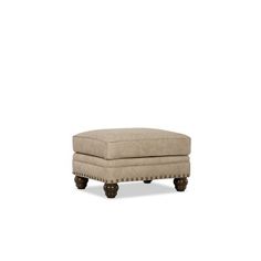 the foot stool is made from wood and has a beige upholstered fabric cover