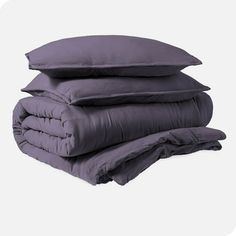 three pillows stacked on top of each other in front of a white background with the same color as the bedding