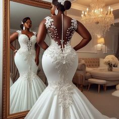 a woman in a wedding dress looking at herself in the mirror with her back to the camera