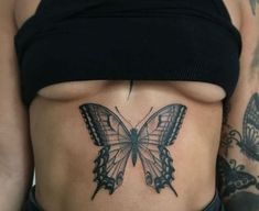 a woman's stomach with a butterfly tattoo on her left side, and the bottom half of her stomach covered in tattoos