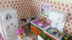 a doll house kitchen with refrigerator, sink and stove