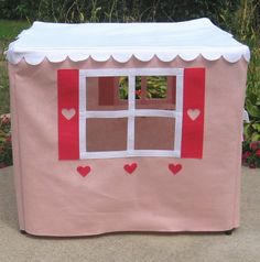 a pink play house with hearts painted on it