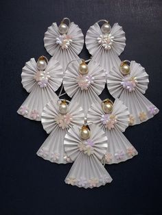 several white fan shaped ornaments with pearls on them