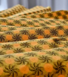 four pieces of fabric with orange and brown designs on them, all lined up together