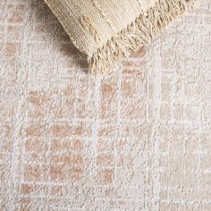 an area rug with fringes on it and a pillow in the middle that is laying down