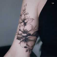 a woman with a black and white flower tattoo on her arm, showing the flowers