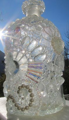 a clear glass bottle sitting on top of a white table next to a tree and building