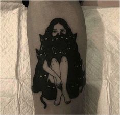 a tattoo on the leg of a woman with a cat sitting in front of her