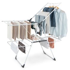 an ironing board with clothes hanging from it's sides and folded shirts on hangers