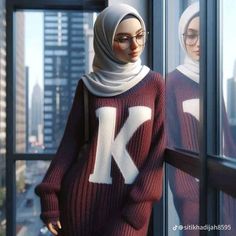 two women in hijabs are standing by a window looking out at the city