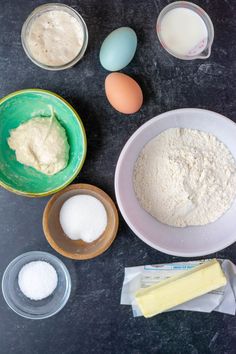 the ingredients to make this cake are in bowls and on top of a black table