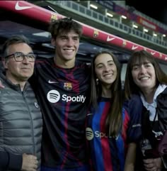 a group of people standing next to each other in front of a soccer goalie