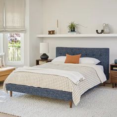 a bedroom with white walls and blue bedding