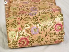 two pieces of fabric on top of each other with flowers and leaves in the middle