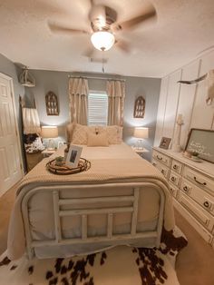 a bed room with a neatly made bed and dressers