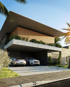 two cars are parked in front of a modern house with palm trees on the side