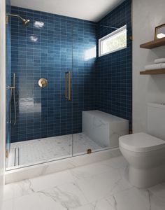 a blue tiled bathroom with a toilet and shower