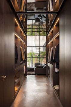 a walk - in closet with lots of clothes on the shelves and open shelving