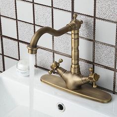 a faucet that is on top of a sink in a room with tiled walls