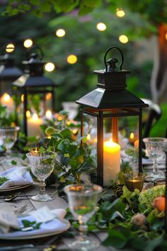 an outdoor dinner table set with candles and place settings