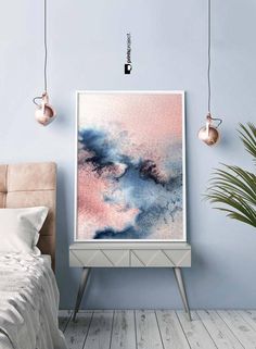 a painting hanging on the wall above a bed in a room with blue walls and wooden floors