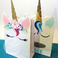 two paper bags with unicorns on them sitting next to each other in front of a wall