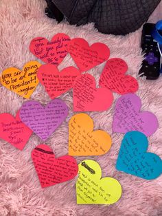 a pile of paper hearts with writing on them