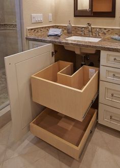 an open drawer in the middle of a bathroom sink