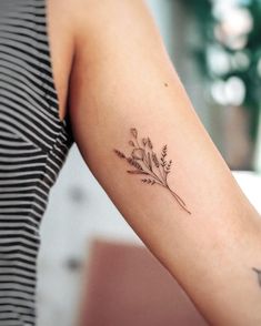 a woman's arm with a flower tattoo on the left side of her arm