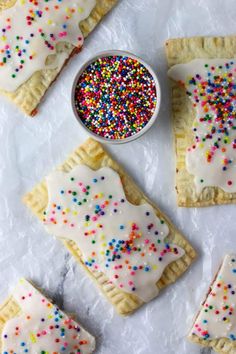 sprinkles and white frosting on top of small pastries