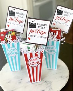 three popcorn boxes with thank you for a perfect year written on them, sitting on a marble plate