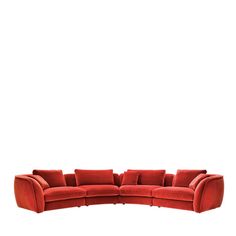 a red sectional sofa with pillows on it's back and one end facing the camera