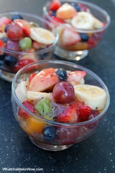 fruit salad in small glass bowls on a black countertop, ready to be eaten