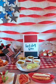 an american flag themed party with hot dogs and other foods on the table for eating