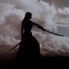 a woman holding two swords in front of the sky with clouds behind her and one arm extended out