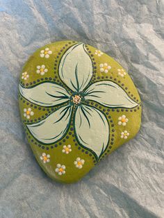 a painted rock with white flowers on it