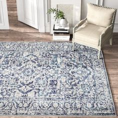 a large blue rug with an ornate design on the floor in front of a chair