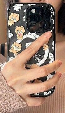 a woman is holding up her phone case with teddy bears on it and the camera