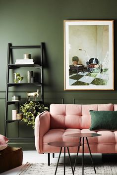 a living room with green walls and pink couches in front of a coffee table