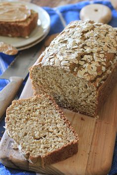 a loaf of oatmeal bread sitting on top of a wooden cutting board