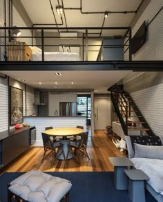 an open concept living and dining area with stairs leading to the upper floor, which also has a loft bed