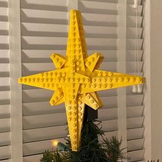 a yellow lego christmas tree topper on a window sill