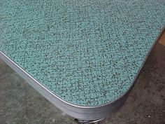 a close up of a metal table with blue paint on the top and bottom surface