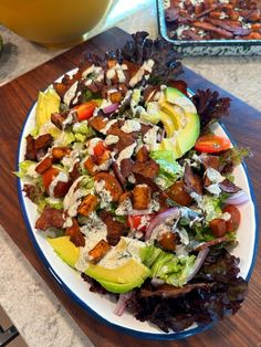 a salad with lettuce, tomatoes, and other vegetables on a white plate