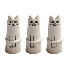 three white ceramic cats sitting next to each other