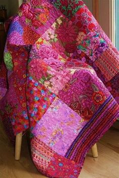 a patchwork quilt on a chair in front of a window