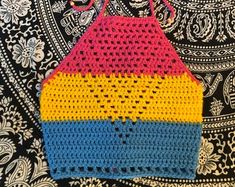 a colorful crocheted bag sitting on top of a black and white tablecloth